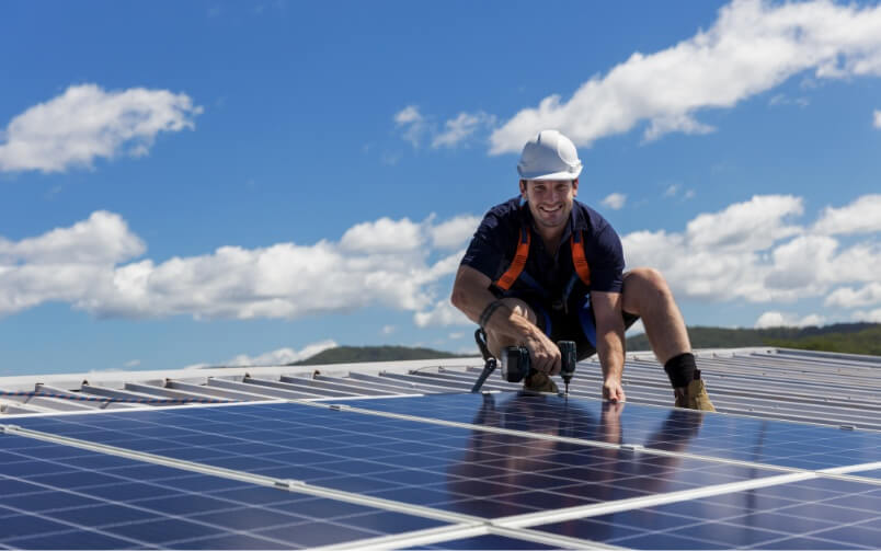 Uśmiechnięty instalator montuje panele słoneczne